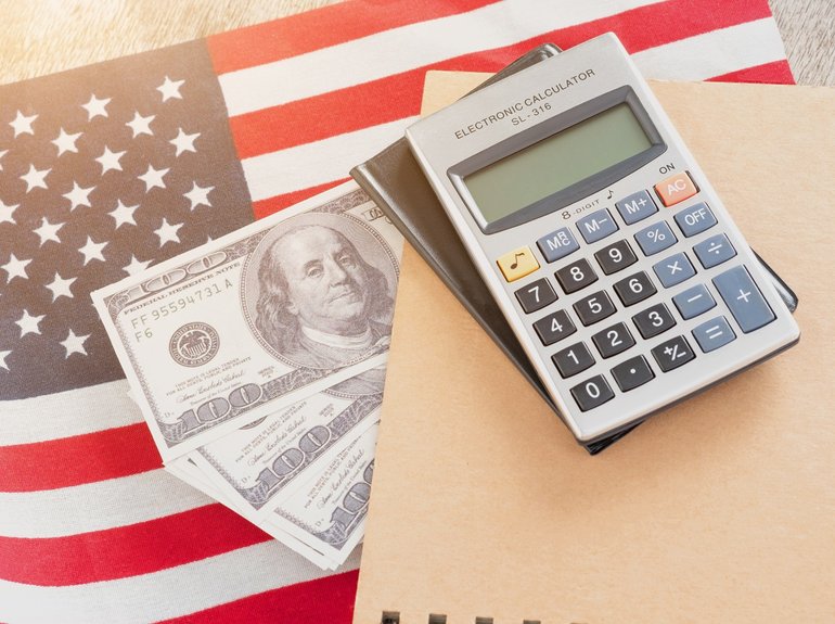 calculadora-de-la-bandera-de-los-estados-unidos-cuaderno-y-dolares-estadounidenses-sobre-un-fondo-de-madera